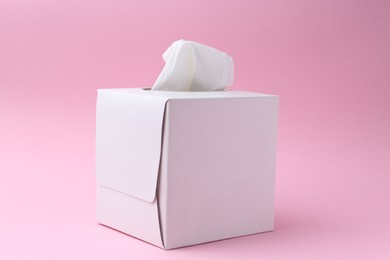 Photo of Box with paper handkerchiefs on pink background