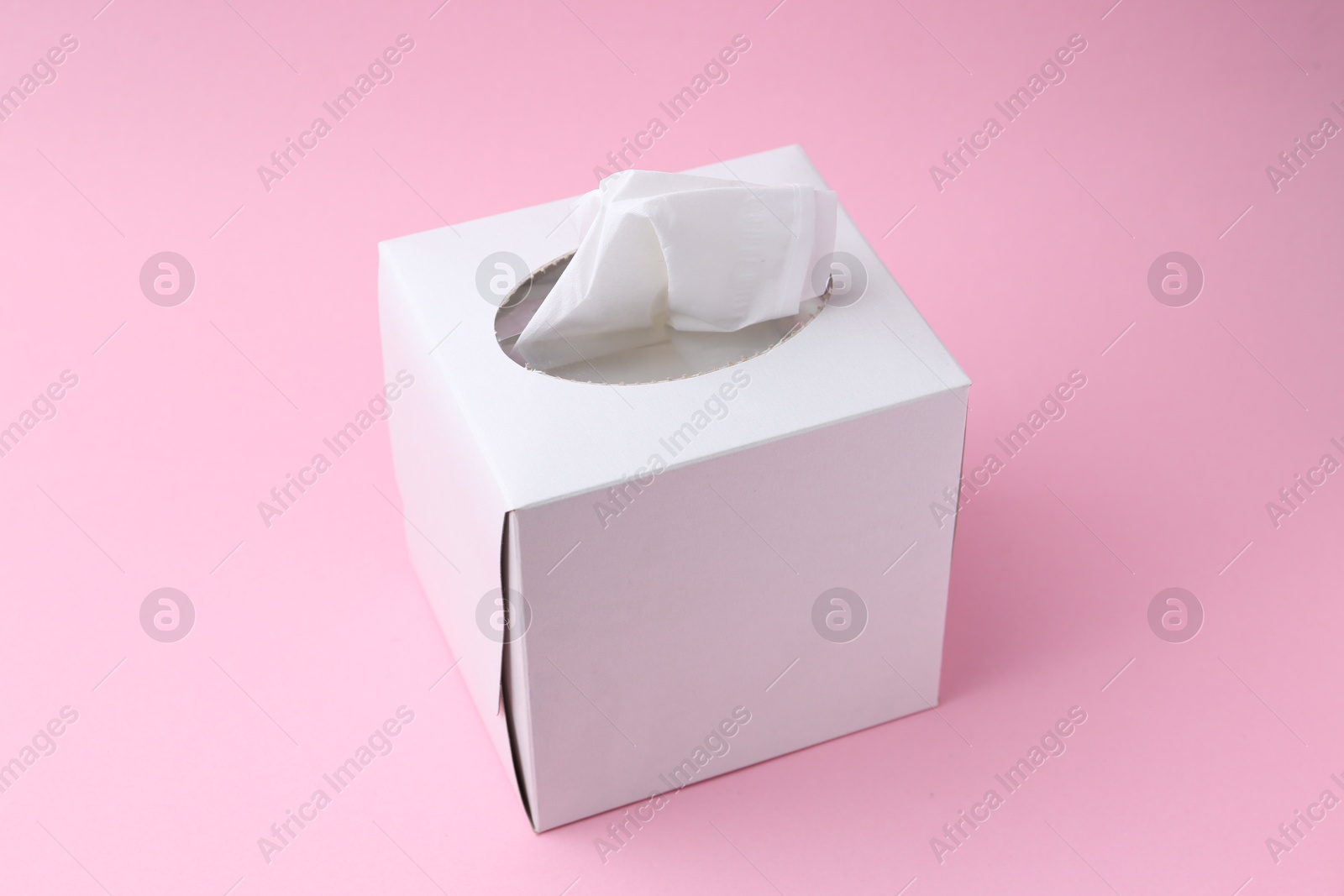 Box with paper handkerchiefs on pink background Photo of Box with paper handkerchiefs on pink background
