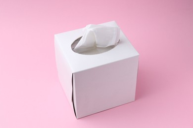 Photo of Box with paper handkerchiefs on pink background