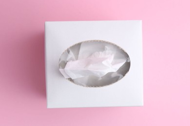 Photo of Box with paper handkerchiefs on pink background, top view