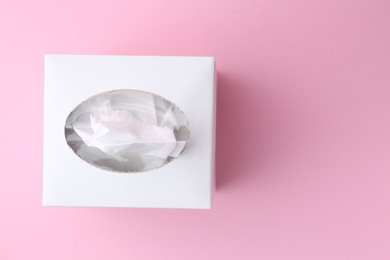 Photo of Box with paper handkerchiefs on pink background, top view. Space for text