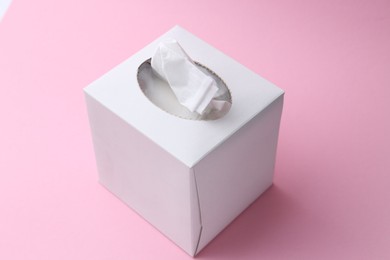 Photo of Box with paper handkerchiefs on pink background, closeup