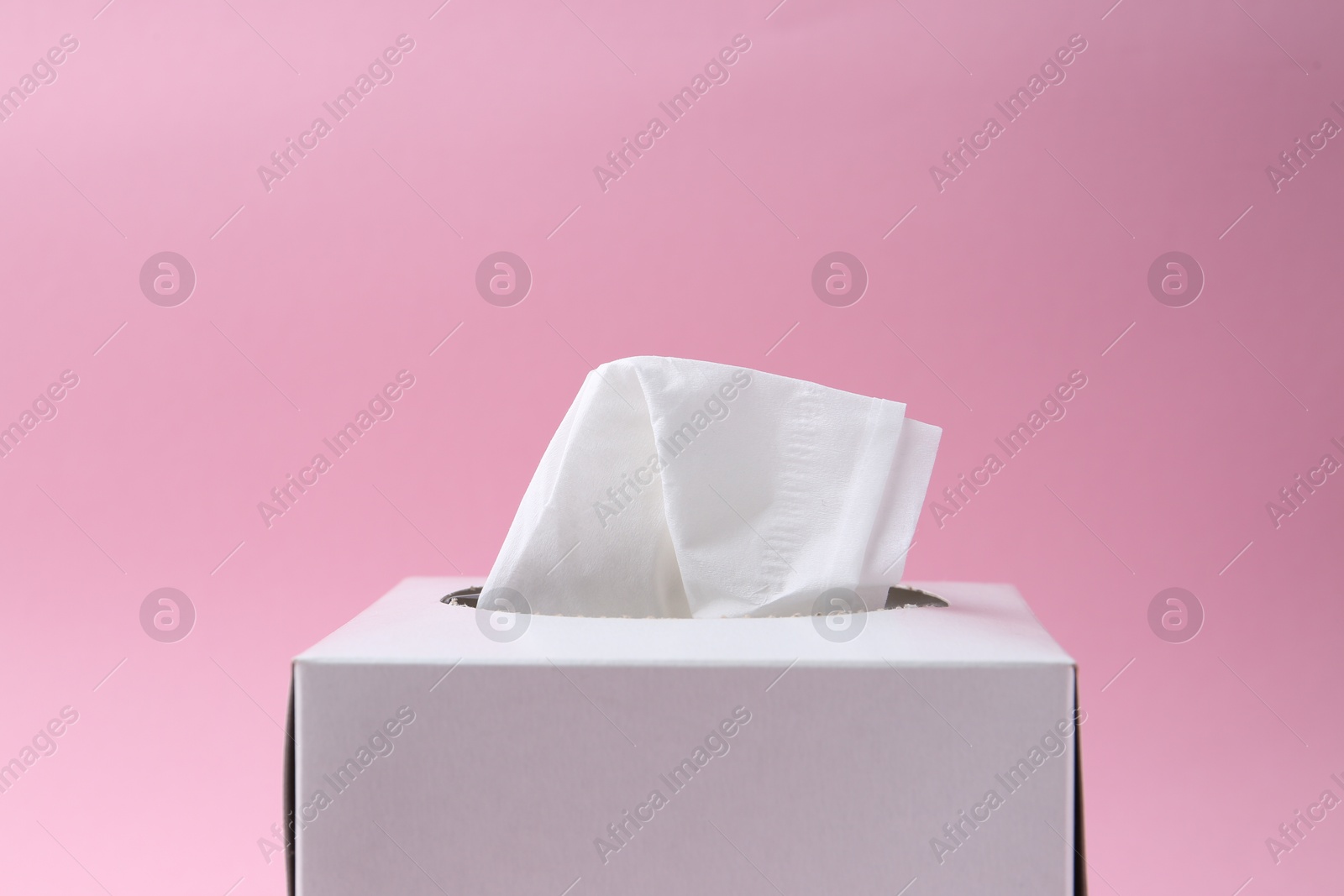 Box with paper handkerchiefs on pink background, closeup. Space for text Photo of Box with paper handkerchiefs on pink background, closeup. Space for text