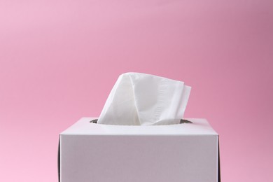 Photo of Box with paper handkerchiefs on pink background, closeup. Space for text
