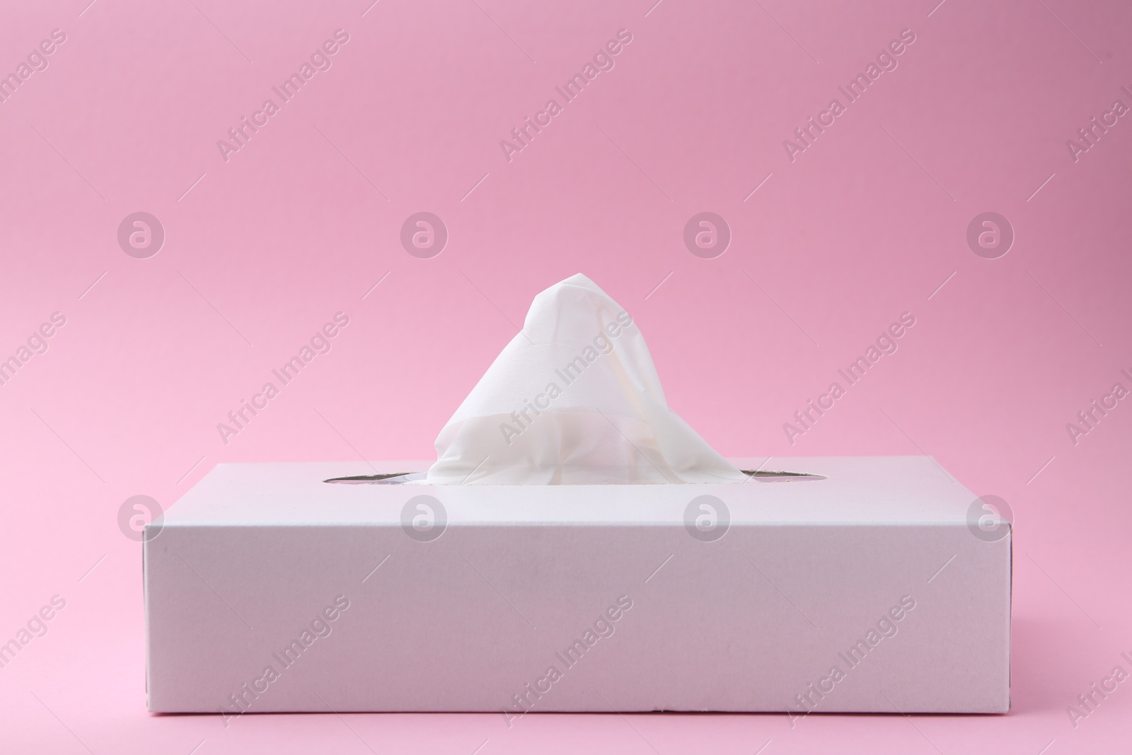 Box with paper handkerchiefs on pink background, closeup. Space for text Photo of Box with paper handkerchiefs on pink background, closeup. Space for text