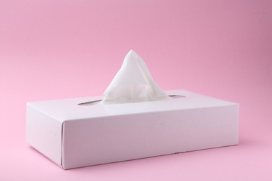 Photo of Box with paper handkerchiefs on pink background, closeup