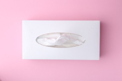 Photo of Box with paper handkerchiefs on pink background, top view