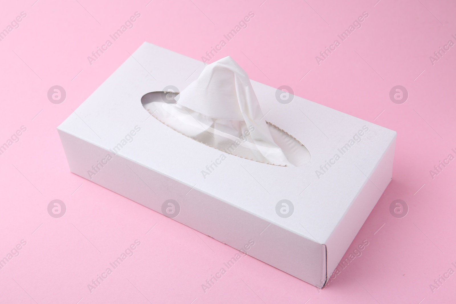 Box with paper handkerchiefs on pink background Photo of Box with paper handkerchiefs on pink background