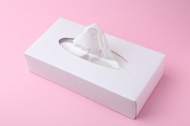 Photo of Box with paper handkerchiefs on pink background