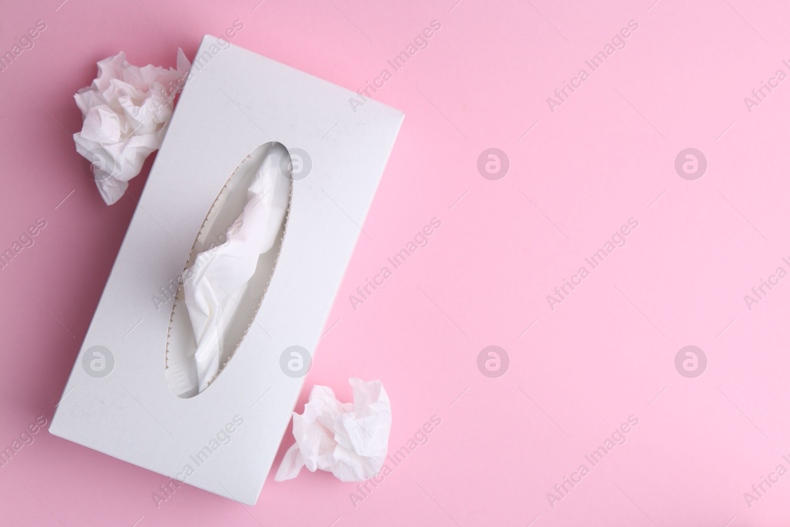 Box with paper handkerchiefs and crumpled tissues on pink background, flat lay. Space for text Photo of Box with paper handkerchiefs and crumpled tissues on pink background, flat lay. Space for text