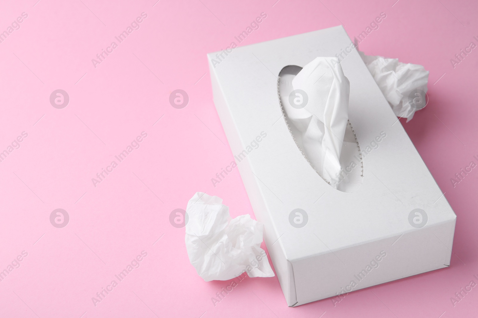 Box with paper handkerchiefs and crumpled tissues on pink background, closeup. Space for text Photo of Box with paper handkerchiefs and crumpled tissues on pink background, closeup. Space for text