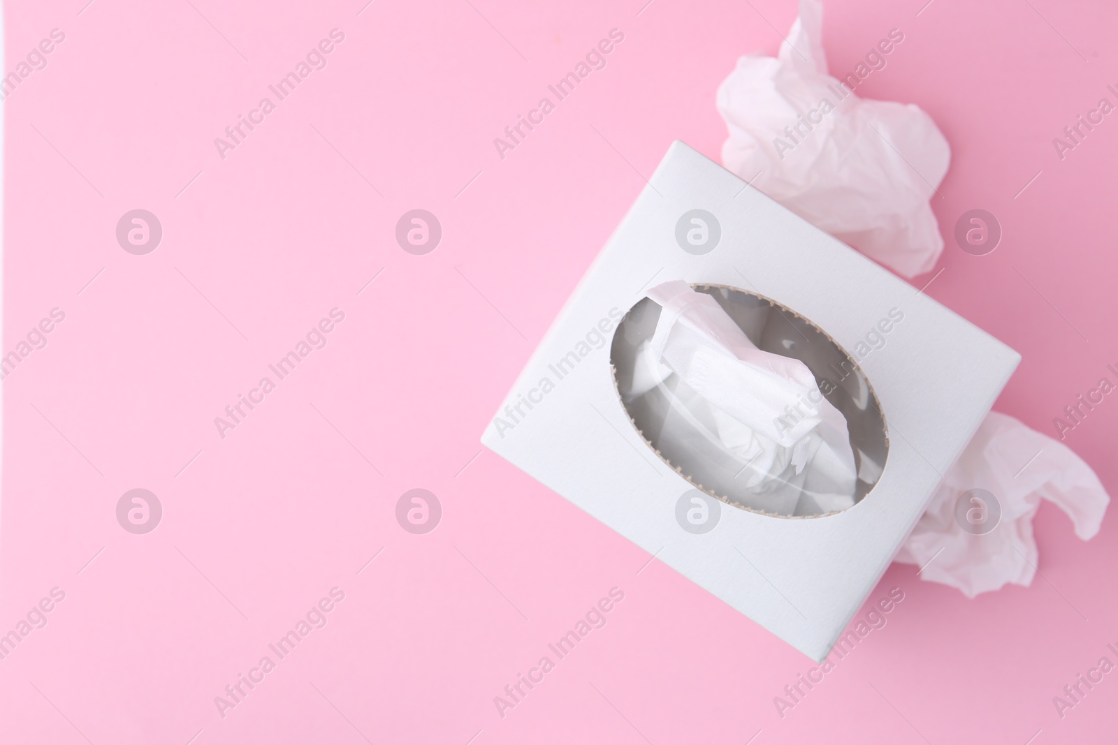 Box with paper handkerchiefs and crumpled tissues on pink background, flat lay. Space for text Photo of Box with paper handkerchiefs and crumpled tissues on pink background, flat lay. Space for text