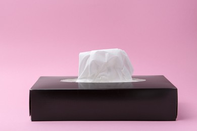 Photo of Box with paper handkerchiefs on pink background, closeup