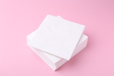 Photo of Stack of white handkerchiefs on pink background, closeup
