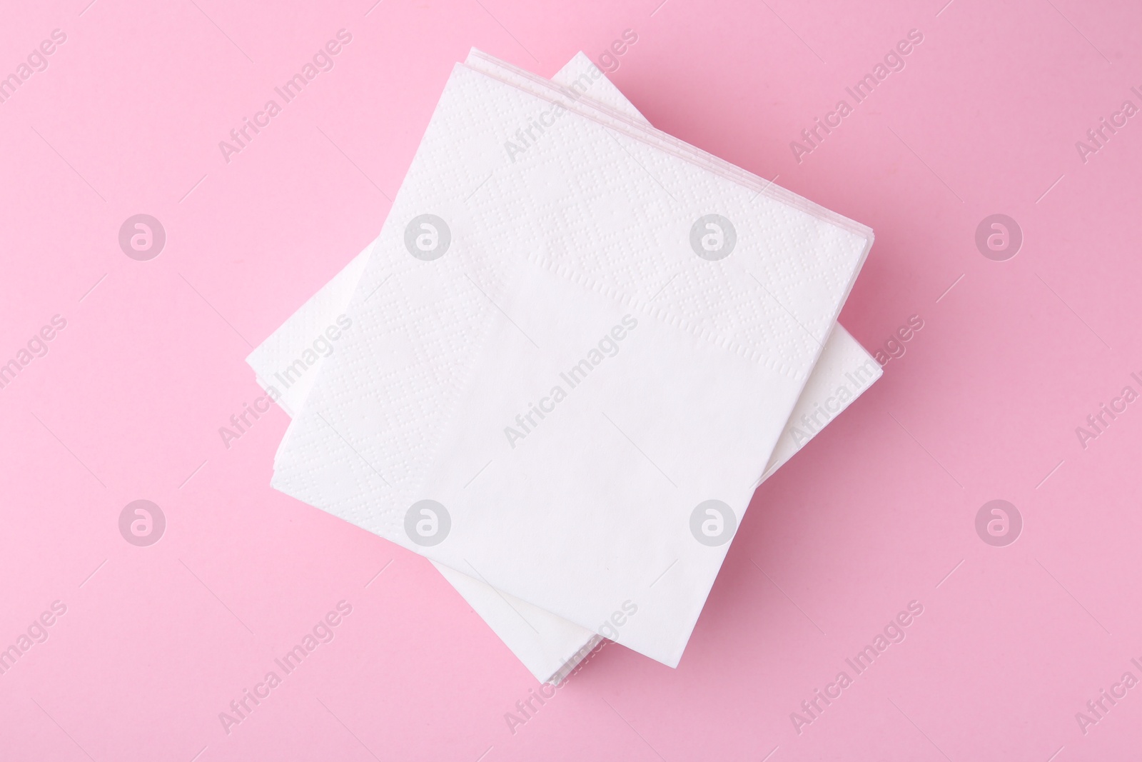 Stack of white handkerchiefs on pink background, top view Photo of Stack of white handkerchiefs on pink background, top view