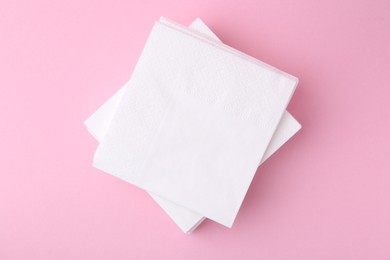 Photo of Stack of white handkerchiefs on pink background, top view