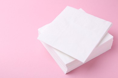 Photo of Stack of white handkerchiefs on pink background, closeup. Space for text