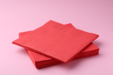 Photo of Stack of red handkerchiefs on pink background, closeup