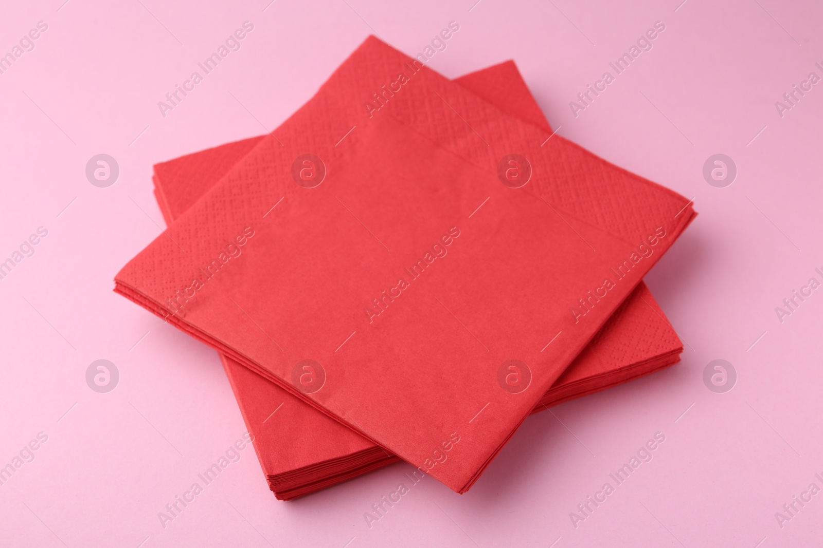 Stack of red handkerchiefs on pink background, closeup Photo of Stack of red handkerchiefs on pink background, closeup