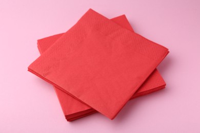 Photo of Stack of red handkerchiefs on pink background, closeup
