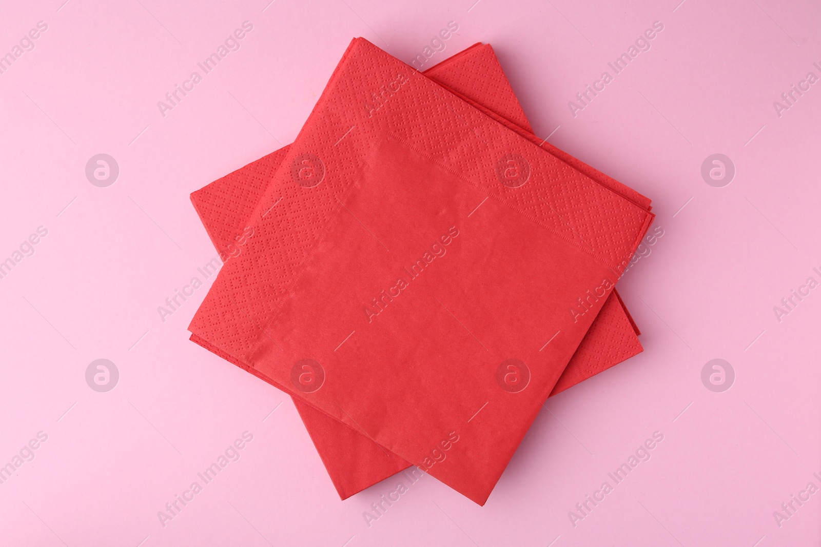 Stack of red handkerchiefs on pink background, top view Photo of Stack of red handkerchiefs on pink background, top view