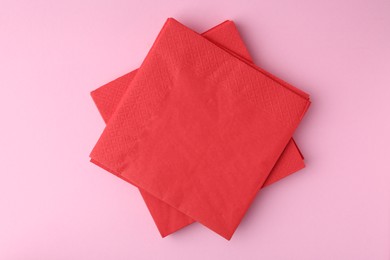 Photo of Stack of red handkerchiefs on pink background, top view
