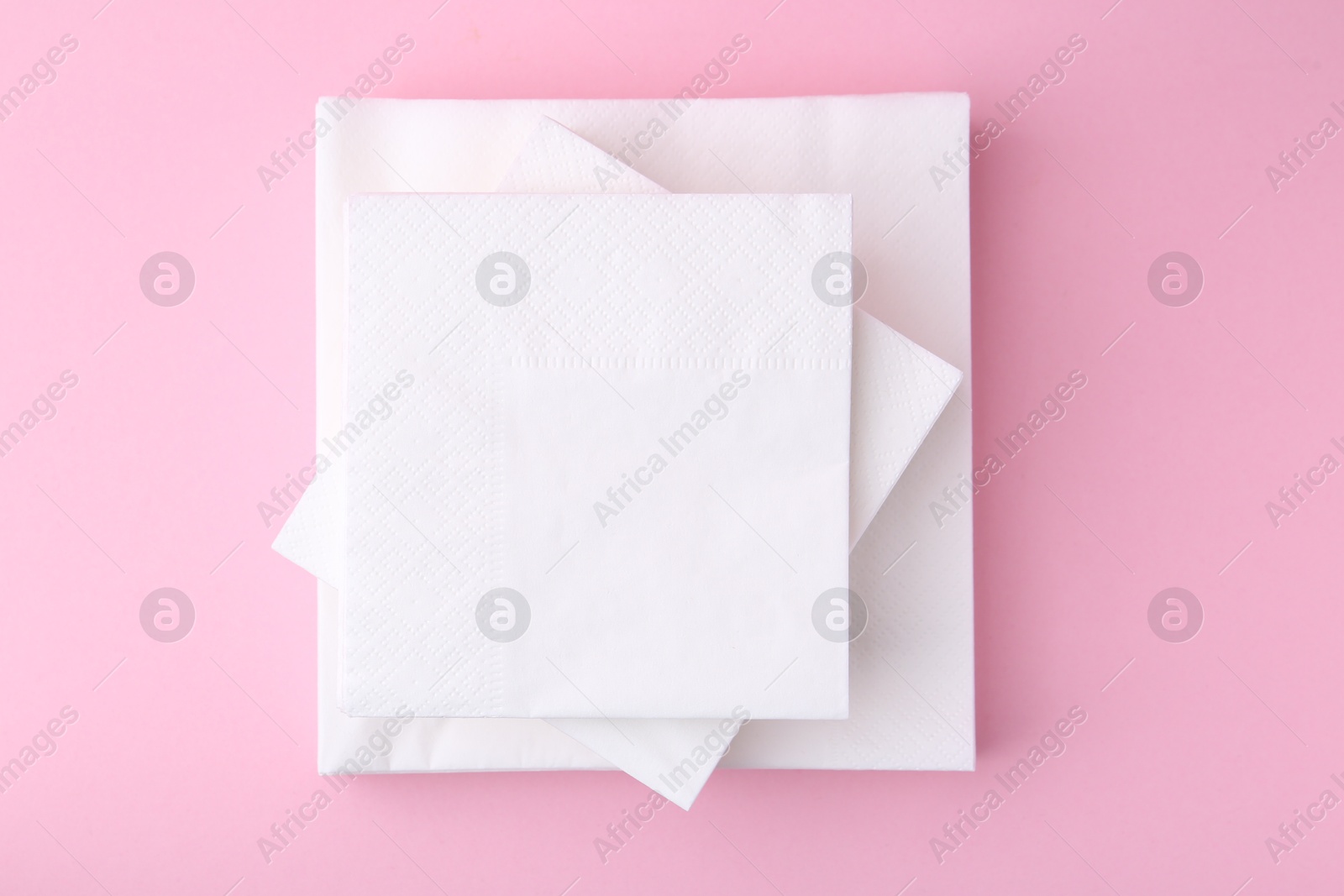 Stack of white handkerchiefs on pink background, top view Photo of Stack of white handkerchiefs on pink background, top view