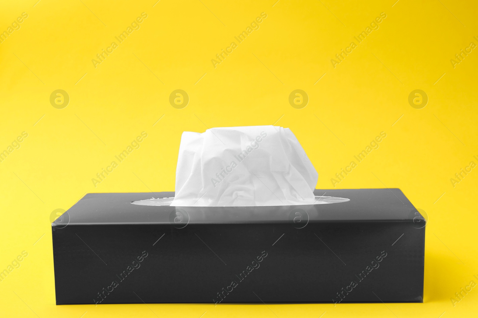 Box with paper handkerchiefs on yellow background. Space for text Photo of Box with paper handkerchiefs on yellow background. Space for text
