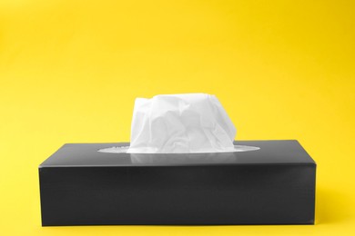 Photo of Box with paper handkerchiefs on yellow background. Space for text