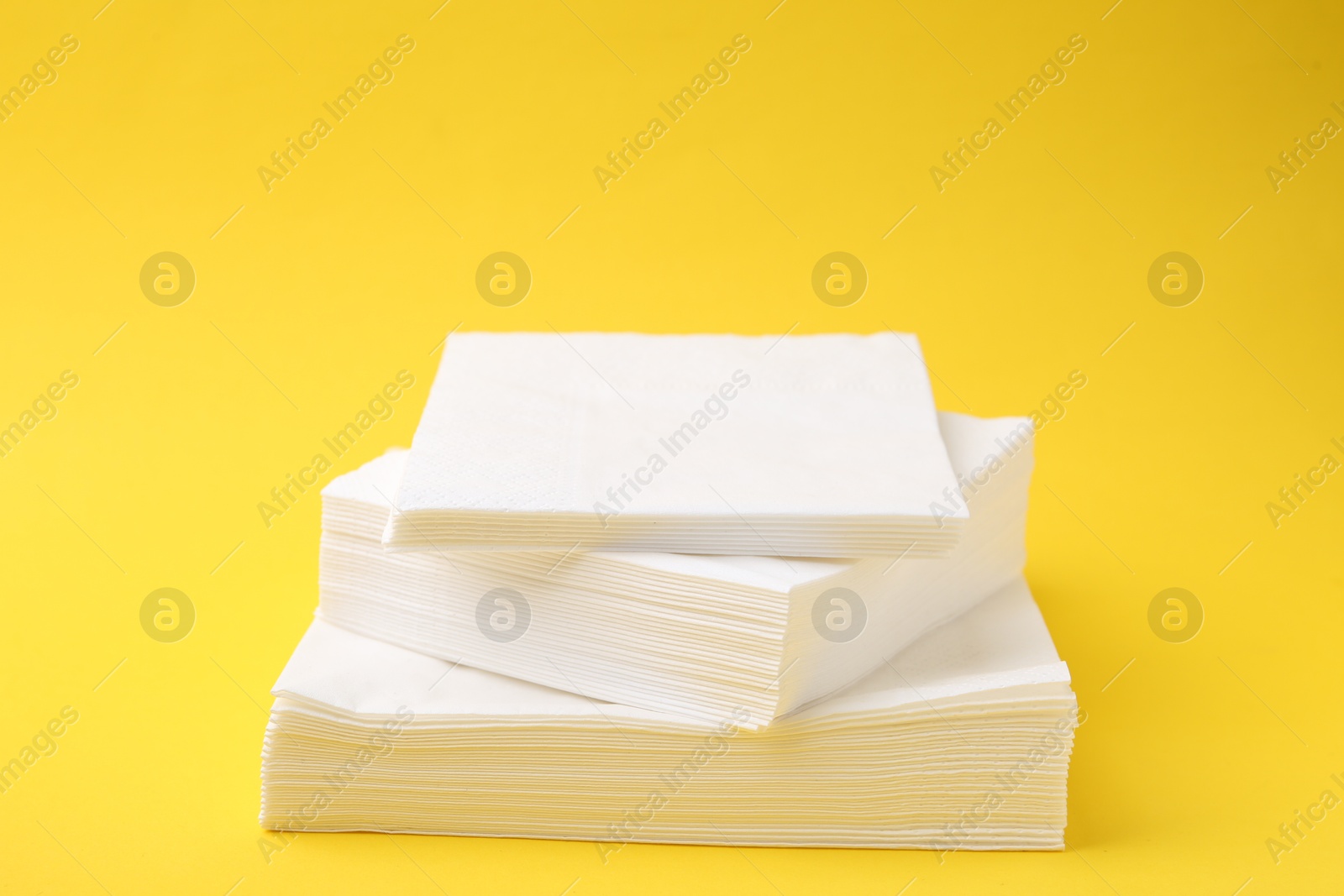 Stack of white handkerchiefs on yellow background, closeup Photo of Stack of white handkerchiefs on yellow background, closeup