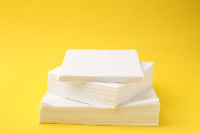 Photo of Stack of white handkerchiefs on yellow background, closeup