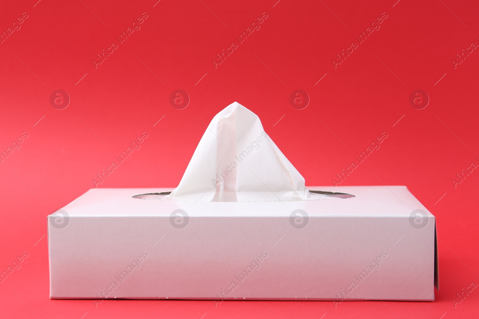 Box with paper handkerchiefs on red background, closeup Photo of Box with paper handkerchiefs on red background, closeup