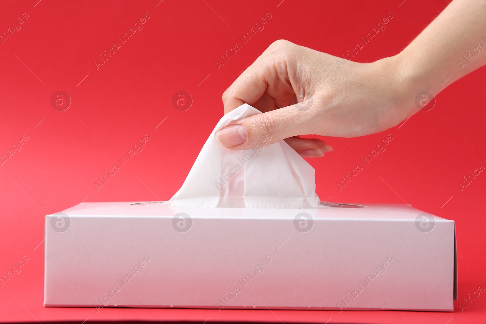 Woman taking handkerchief out of box on red background, closeup Photo of Woman taking handkerchief out of box on red background, closeup