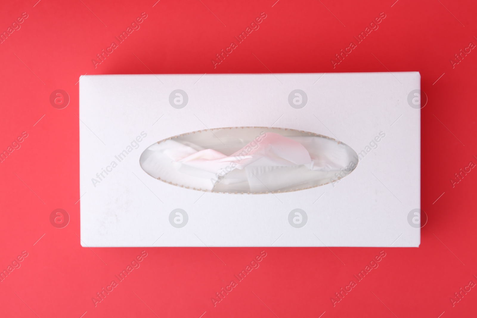 Box with paper handkerchiefs on red background, top view Photo of Box with paper handkerchiefs on red background, top view