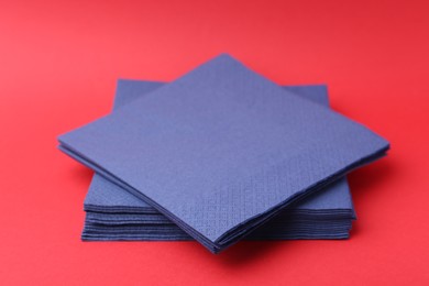 Photo of Stack of blue handkerchiefs on red background, closeup