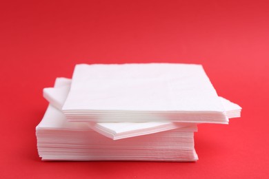 Photo of Stack of white handkerchiefs on red background, closeup