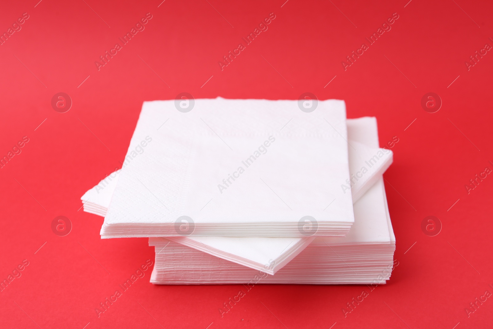 Stack of white handkerchiefs on red background, closeup Photo of Stack of white handkerchiefs on red background, closeup