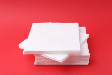 Photo of Stack of white handkerchiefs on red background, closeup