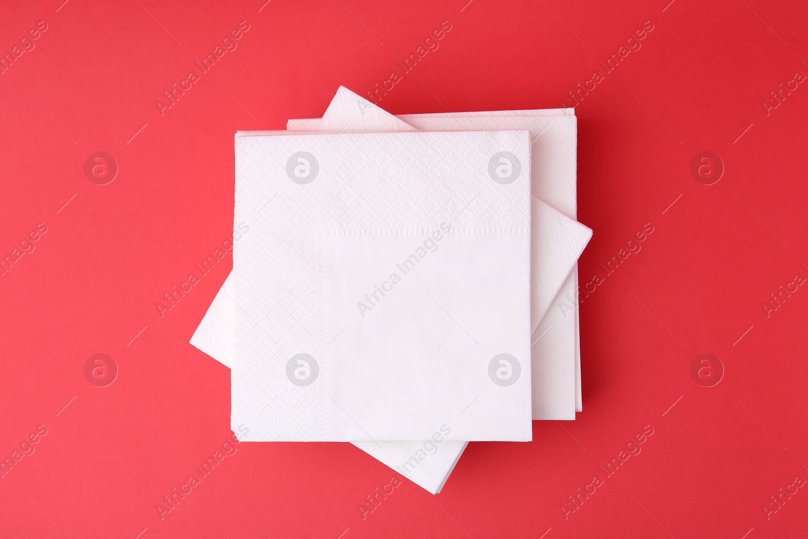 Stack of white handkerchiefs on red background, top view Photo of Stack of white handkerchiefs on red background, top view