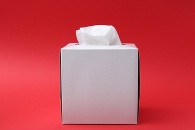 Photo of Box with paper handkerchiefs on red background