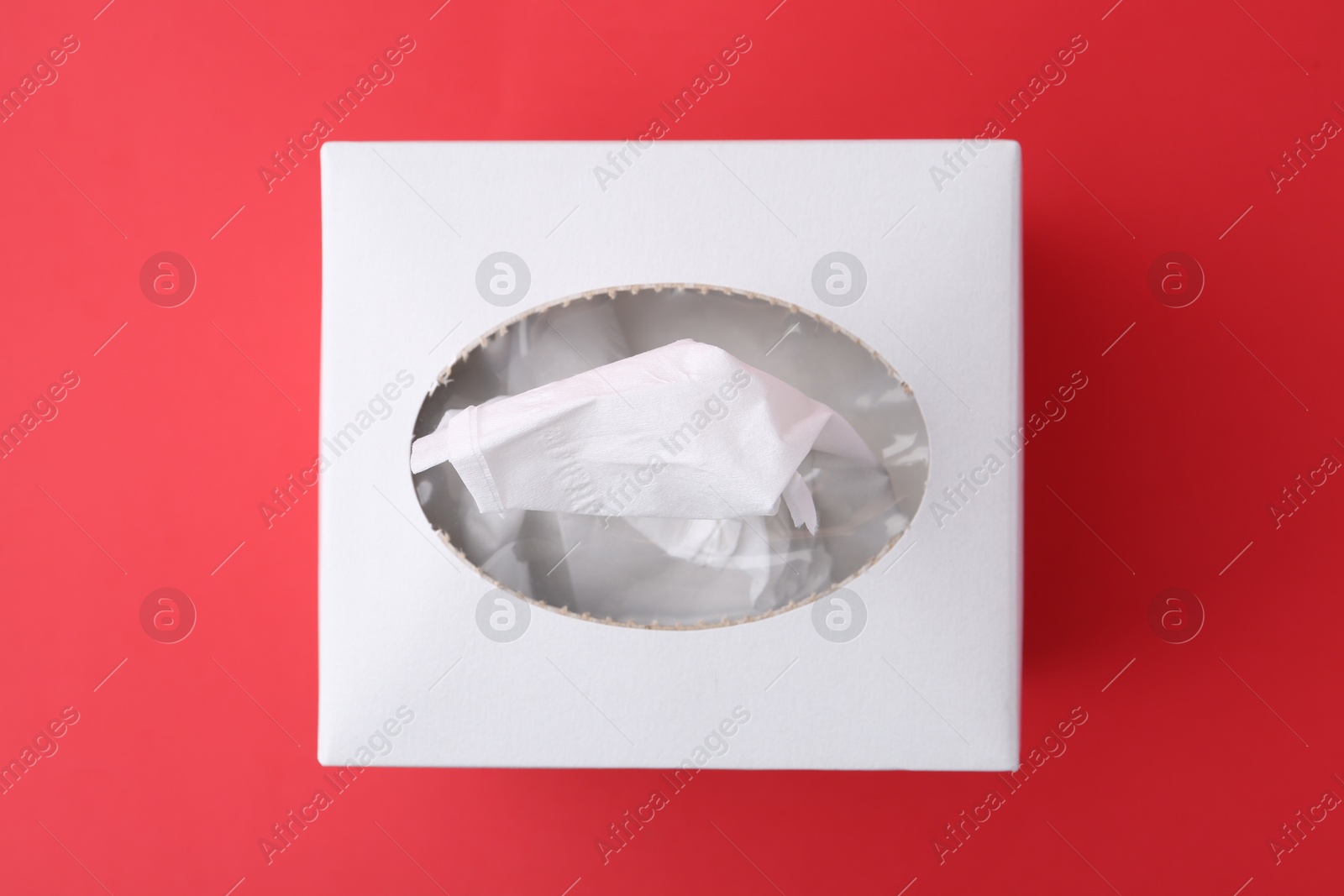 Box with paper handkerchiefs on red background, top view Photo of Box with paper handkerchiefs on red background, top view