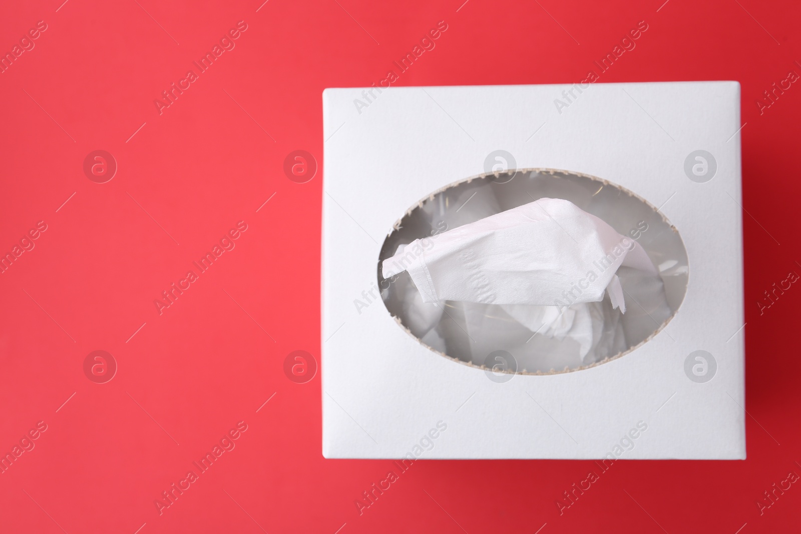 Box with paper handkerchiefs on red background, top view Photo of Box with paper handkerchiefs on red background, top view