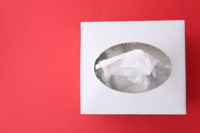 Photo of Box with paper handkerchiefs on red background, top view