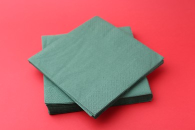 Photo of Stack of green handkerchiefs on red background, closeup