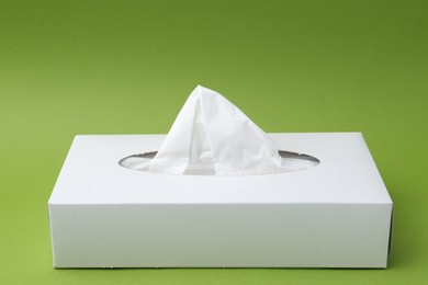 Photo of Box with paper handkerchiefs on green background