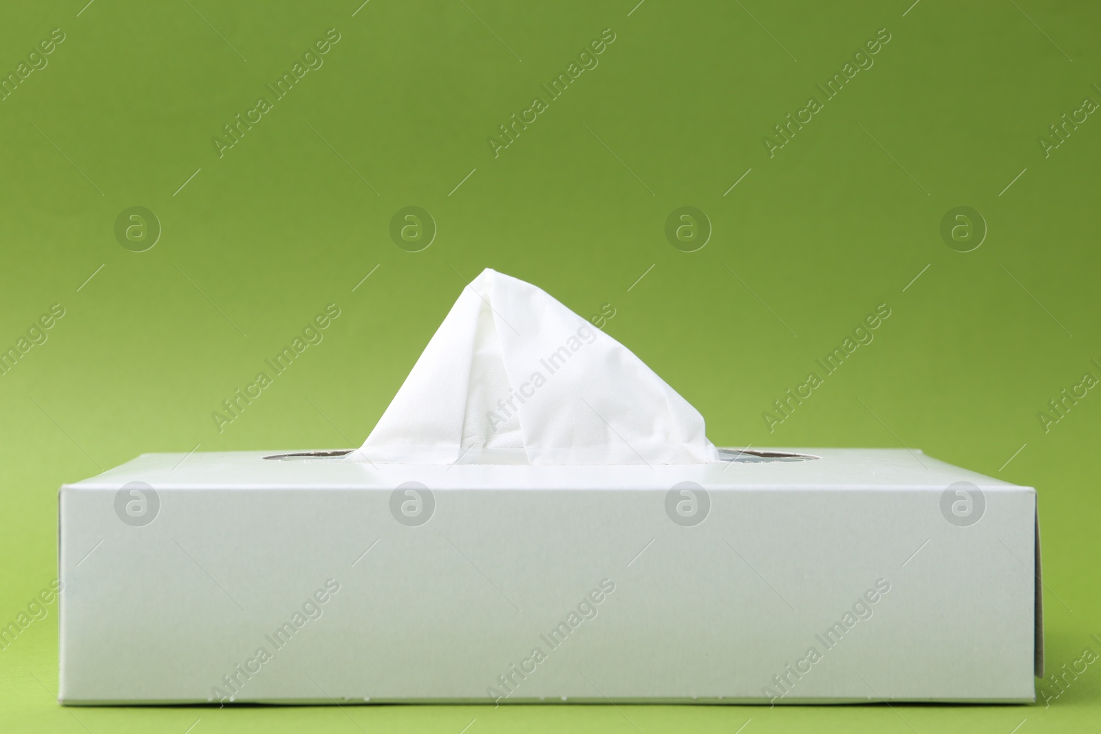 Box with paper handkerchiefs on green background. Space for text Photo of Box with paper handkerchiefs on green background. Space for text