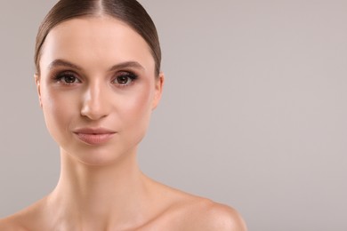 Photo of Portrait of beautiful young woman on gray background, space for text