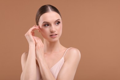 Photo of Portrait of beautiful young woman on beige background, space for text