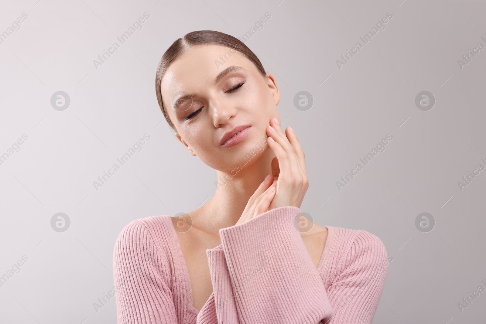 Portrait of beautiful young woman on gray background Photo of Portrait of beautiful young woman on gray background