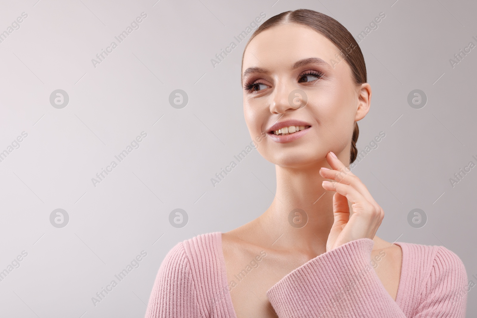 Portrait of beautiful young woman on gray background, space for text Photo of Portrait of beautiful young woman on gray background, space for text
